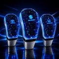 Crystal LED gear shift knob with Toyota, Suzuki and Honda logo variants on a dark blue automotive background