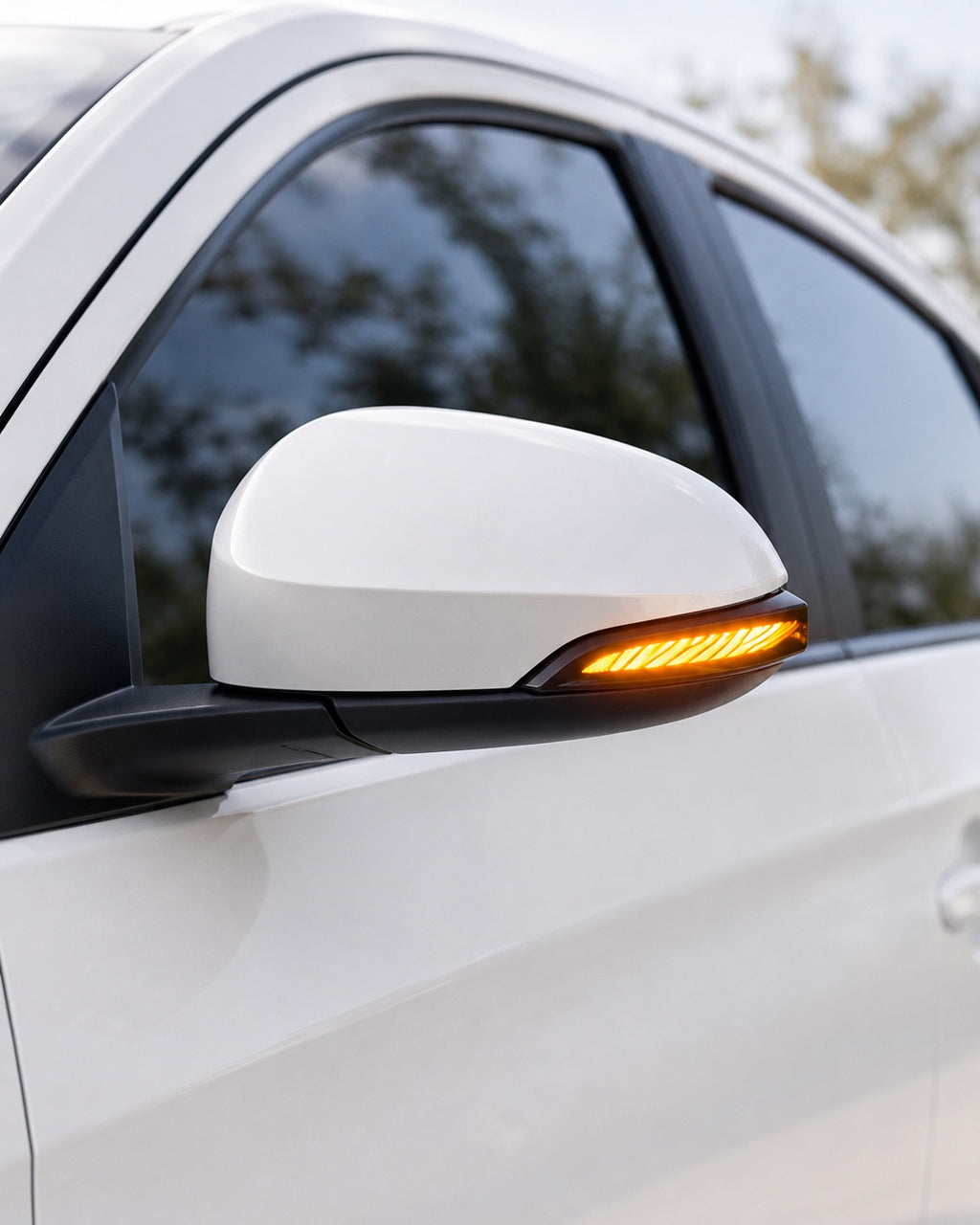 Wing style LED side mirror indicator showing amber turn signal on a Toyota car